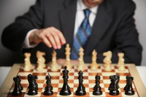 Business professional playing chess, representing strategic planning, leadership, decision-making, and competitive business strategy.