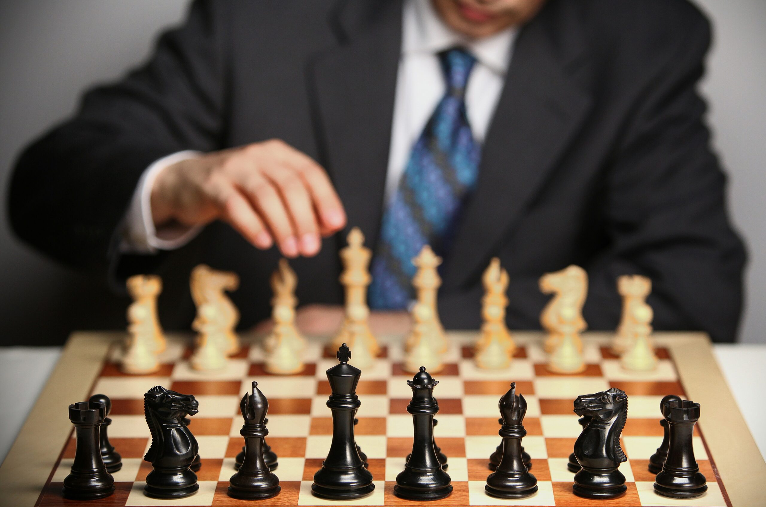 Business professional playing chess, representing strategic planning, leadership, decision-making, and competitive business strategy.