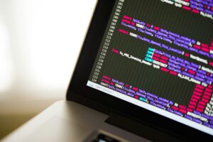 Laptop displaying programming code and database queries, representing software development, coding, data analysis, and technology solutions.