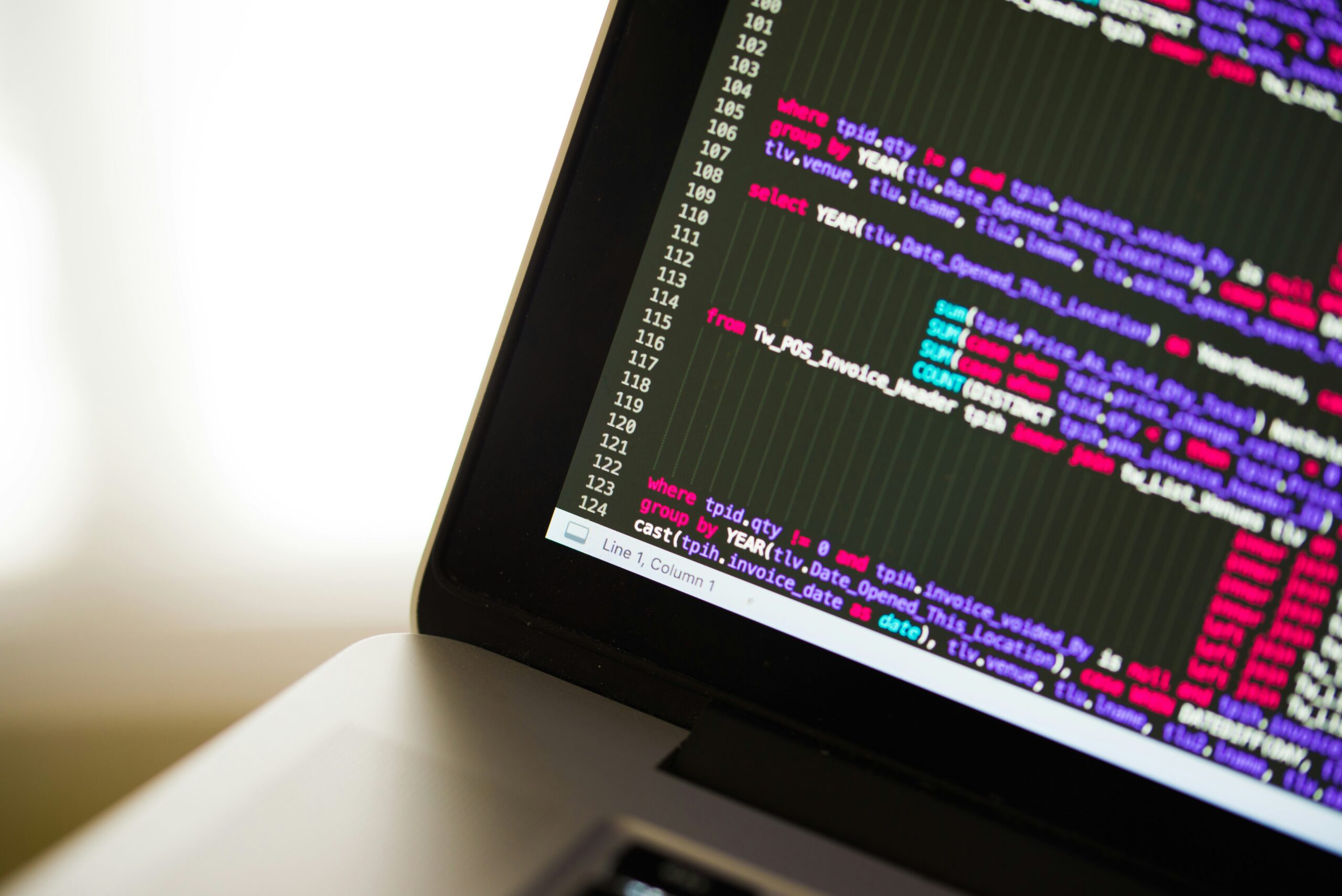 Laptop displaying programming code and database queries, representing software development, coding, data analysis, and technology solutions.