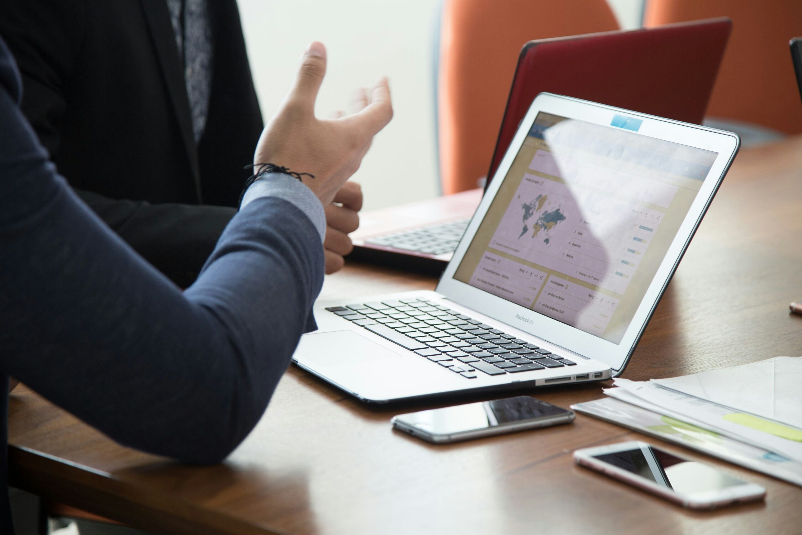 Business professional analyzing dashboard metrics and performance reports on a laptop during a strategy meeting.